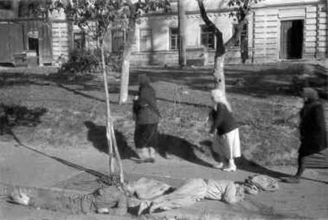 Babi-Yar locals pass corpes lying on the street near the Yevbaz